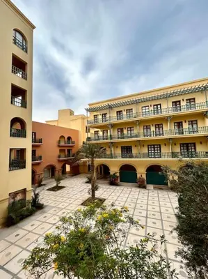 a large building with a courtyard in front of it at SunShine AbuTig Marina in Hurghada