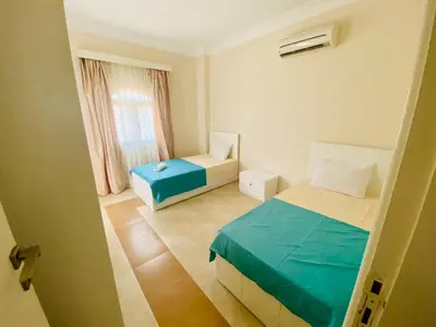 a small bedroom with two beds and a window at Villa 6 in Hurghada