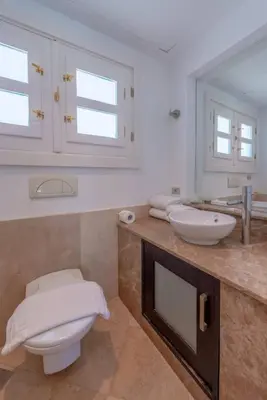 a bathroom with a toilet and a sink and a mirror at Golf Luxury villa with private pool in Hurghada