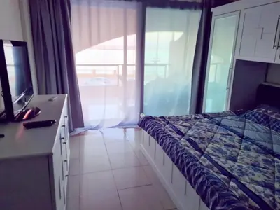 a bedroom with a bed and a tv and a window at The View Residence Studio in Hurghada