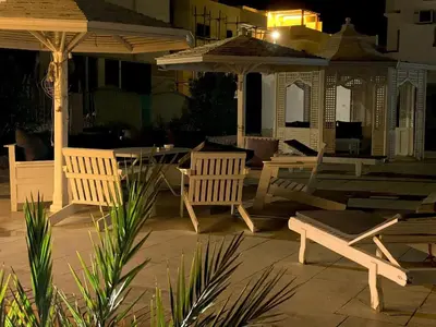 a patio with a table and chairs and an umbrella at Hurghada-Magawish Villa 6 in Hurghada