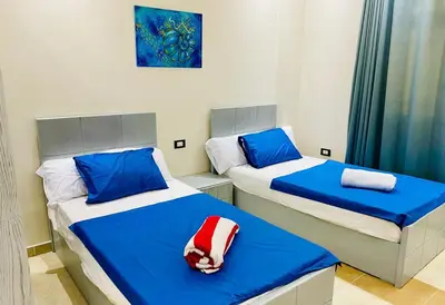 two beds in a room with blue and white at Hurghada-Magawish Villa 6 in Hurghada