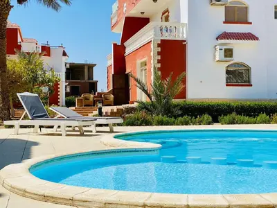 a swimming pool in front of a house at فيلا 1☆ in Hurghada