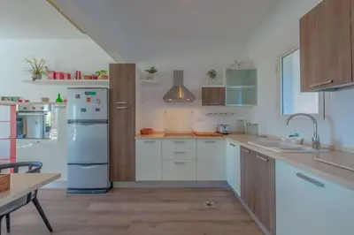 a kitchen with white cabinets and a blue refrigerator at unique flat_ garden and lagoon in Hurghada