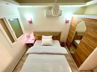 a small bedroom with a bed and two lamps at Selena Bay Resort & beach in Hurghada