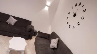 a living room with a couch and a clock on the wall at Selena Bay Resort & beach in Hurghada