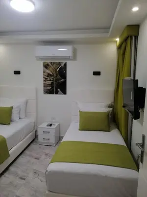 a bedroom with two beds and a flat screen tv at Selena Bay Resort & beach in Hurghada