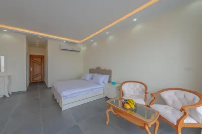a bedroom with a bed and two chairs and a table at unique villa with heated pool and Spa in Hurghada