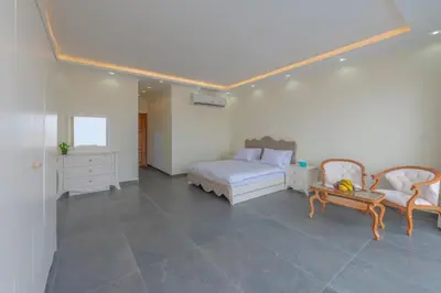 a bedroom with a bed and two chairs and a table at unique villa with heated pool and Spa in Hurghada