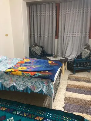 a bedroom with two beds and a window with curtains at NUB Guest House in Aswan