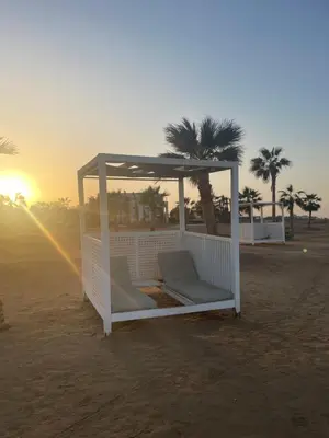 a gazebo on the beach with the sunset at Fabulous Sea view 1 BR & private Garden to the pool at Mangroovy in Hurghada
