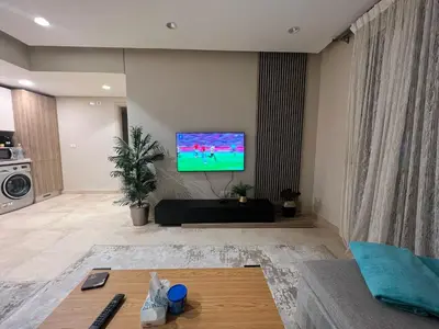 a living room with a flat screen tv on a wall at Fabulous Sea view 1 BR & private Garden to the pool at Mangroovy in Hurghada