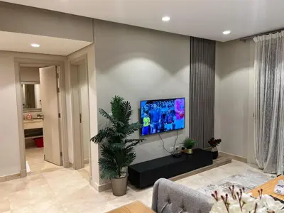 a living room with a flat screen tv on a wall at Fabulous Sea view 1 BR & private Garden to the pool at Mangroovy in Hurghada