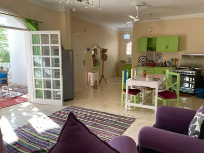 a living room with a table and a kitchen at Roses House Ladies or families only in Luxor