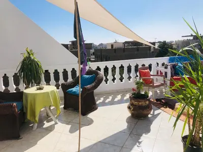 a patio with chairs and a table on a roof at Roses House Ladies or families only in Luxor