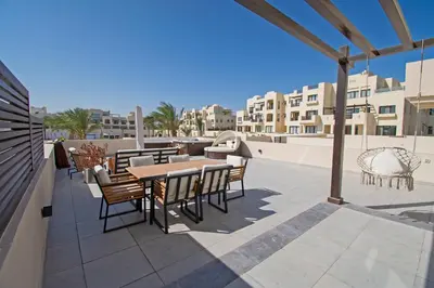 a patio with tables and chairs on a roof at Ollystays Fanadir Marina 1BR Heated Jacuzzi in Hurghada