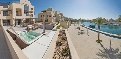 a swimming pool with a hot tub next to some buildings at Ollystays Fanadir Marina 1BR Heated Jacuzzi in Hurghada