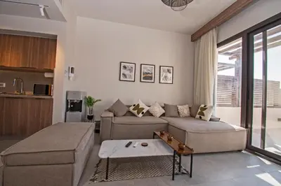 a living room with a couch and a table at Ollystays Fanadir Marina 1BR Heated Jacuzzi in Hurghada