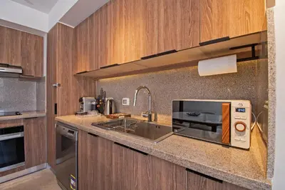 a kitchen with a sink and a microwave at Ollystays Fanadir Marina 1BR Heated Jacuzzi in Hurghada