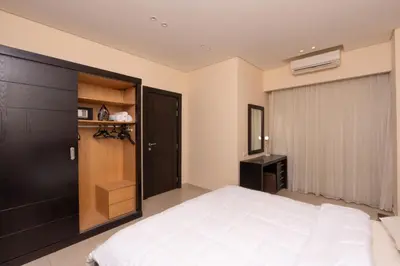 a bedroom with a large white bed and a closet at One bedroom with sea view in the centre in Hurghada