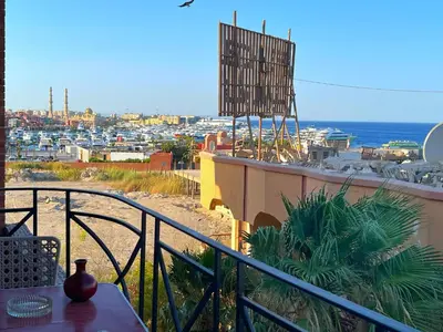 a balcony with a view of a city and the ocean at One bedroom with sea view in the centre in Hurghada