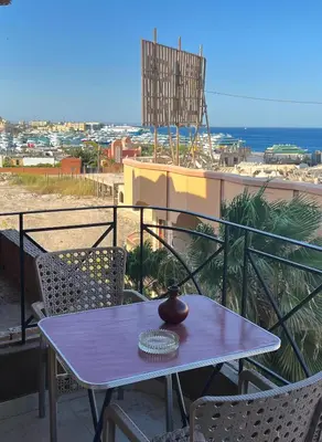 a table and chairs on a balcony with a view of the ocean at One bedroom with sea view in the centre in Hurghada