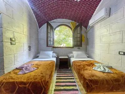 two beds in a room with a window at Kashta Nubian Guest Houst in Aswan