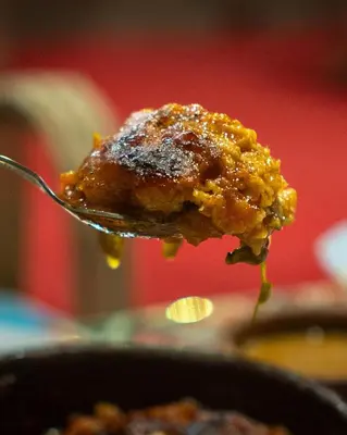 a spoon with a piece of food in a pan at Kashta Nubian Guest Houst in Aswan