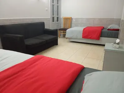 a living room with a couch and a bed and a chair at Abeer Guest House in Luxor