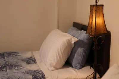 a bedroom with a bed with pillows and a lamp at Abeer Guest House in Luxor