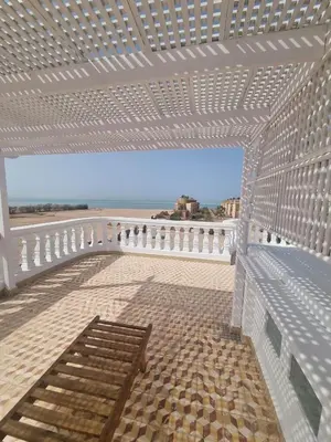 a white pergola with a bench on a balcony at White House Hurghada in Hurghada