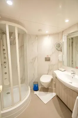 a white bathroom with a toilet and a sink at Five Star Deluxe River Kruz from Aswan to Luxor 3 Nights in Aswan
