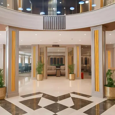 a lobby with pillars and plants in a building at Five Star Deluxe River Kruz from Aswan to Luxor 3 Nights in Aswan
