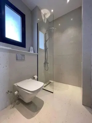 a bathroom with a toilet and a glass shower at Captivating 1 BDR Fanadir Marina in Hurghada