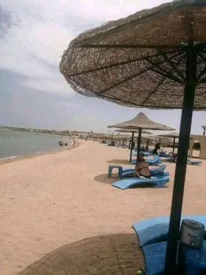 a person sitting on the beach under an umbrella at Cecelia Resort Hurghada in Hurghada