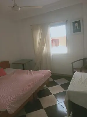 a bedroom with two beds and a window and a checkered floor at Sheraton Plaza Marina Blast 2 bedroom 2 bathroom in Hurghada