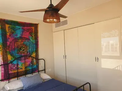 a bedroom with a bed and a ceiling fan at Mangroovy - Divine 1BR Hotel view in Hurghada