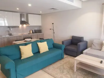 a living room with a blue couch and a table at Mangroovy - Divine 1BR Hotel view in Hurghada