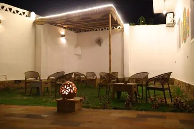 a group of chairs and tables in a patio at night at Diamond Guest House in Luxor