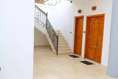 a hallway with a staircase and two wooden doors at Diamond Guest House in Luxor