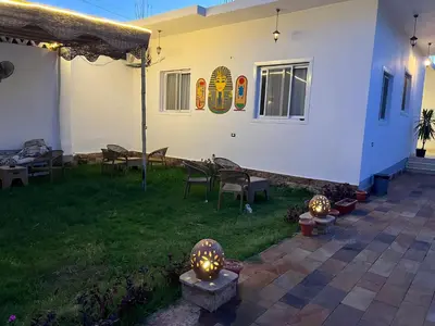 a backyard with a patio with tables and chairs at Diamond Guest House in Luxor