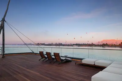 a boat deck with chairs and a view of the water at STORIA THE DAHABEYA - Mondays from Luxor for 4 & 7 Nights, and Fridays from Aswan for 3 & 7 Nights - Available for Private Bookings in Luxor
