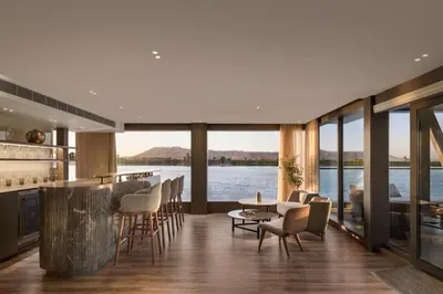 a living room with a view of the water at STORIA THE DAHABEYA - Mondays from Luxor for 4 & 7 Nights, and Fridays from Aswan for 3 & 7 Nights - Available for Private Bookings in Luxor