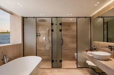 a bathroom with a shower and a tub and a sink at STORIA THE DAHABEYA - Mondays from Luxor for 4 & 7 Nights, and Fridays from Aswan for 3 & 7 Nights - Available for Private Bookings in Luxor
