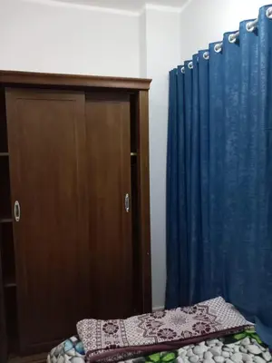 a bedroom with a bed and a blue curtain at Ikea flat 6 in Hurghada
