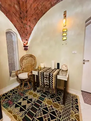 a living room with a table and a chair at West Bank luxury villa in Luxor