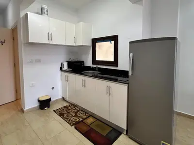a kitchen with white cabinets and a silver refrigerator at Hurghada Concierge at Turtles Beach Resort in Hurghada