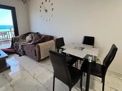 a living room with a table and chairs and a couch at Hurghada Concierge at Turtles Beach Resort in Hurghada