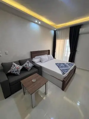 a hotel room with a bed and a couch at Casablanca beach family suites in Hurghada