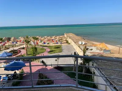 a view of a beach with umbrellas and the ocean at Casablanca beach family suites in Hurghada